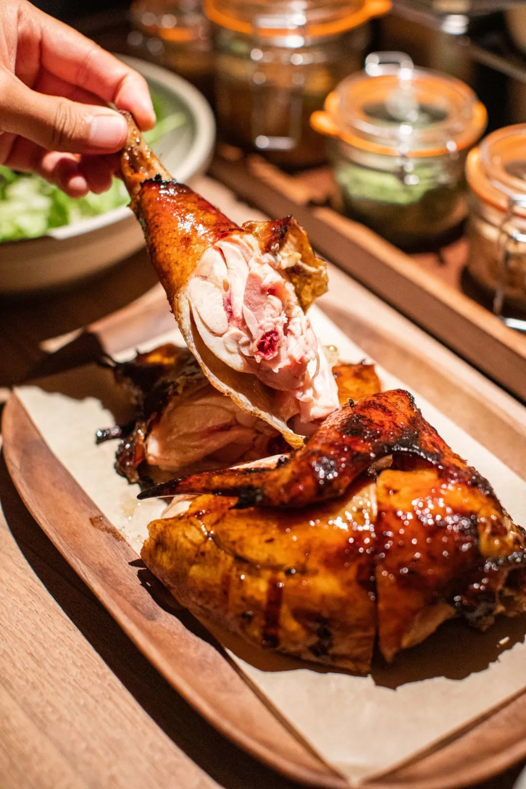 这只鸡被反复折腾,最终上桌时薄薄一层的酥皮渗着鸡油,带着苹果木烟熏