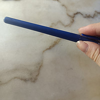 这支蓝色笔的设计。它的握持区域设计得很贴合手指曲线，让手指可以自然地包裹在上面