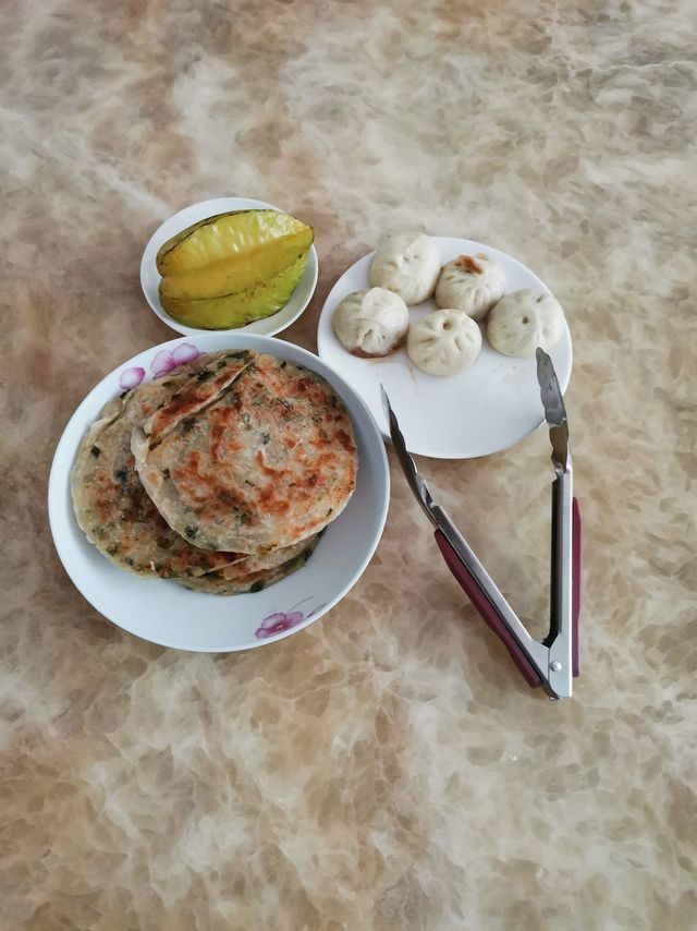 今日份午餐：两个小笼包、一个葱油饼、一个杨桃