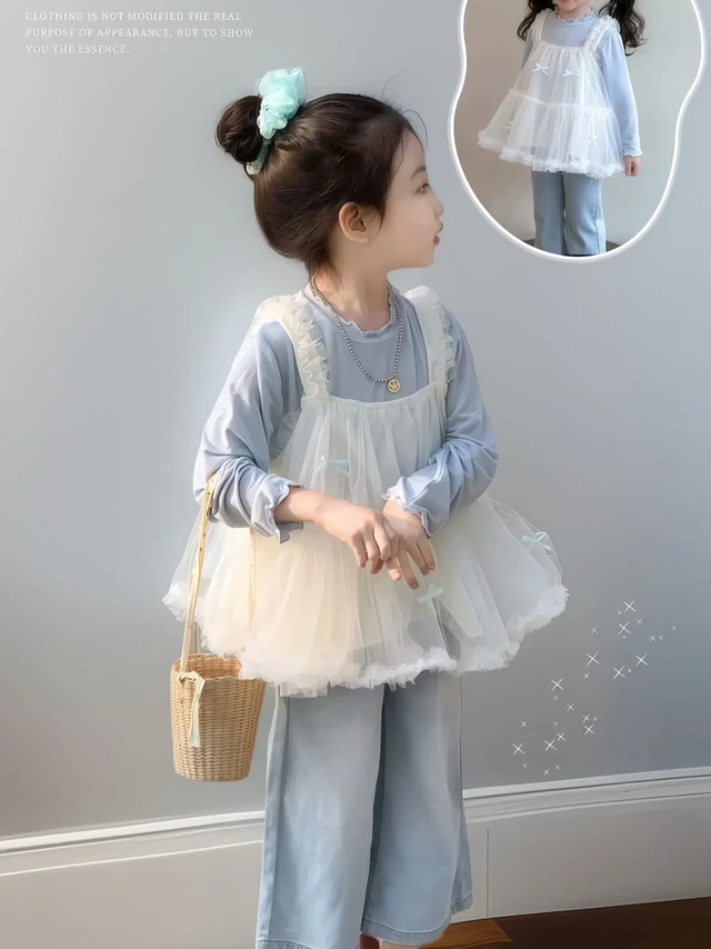 被甜晕！女宝这套仙女风穿搭美哭啦。宝子们，我家女鹅穿上这套简直就是小仙女本仙！浅蓝色的长袖上衣，搭配同色系的阔腿牛仔裤，清新又舒适 。
外面再罩上一层带蕾丝花边的白色网纱吊带，轻盈又梦幻。她头戴薄荷绿