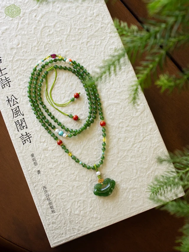 新中式｜松风闲诗·原创和田玉项链🌿🌿。碧玉流光，凝于一枚平安锁✨
素链轻绕，偶遇几颗彩宝的点缀，仿佛时光里不经意的小确幸。是颈间的静好，也是贴身的祝愿🍀🍀
#创作灵感 #玉石魅力 #原创手作 #古风饰