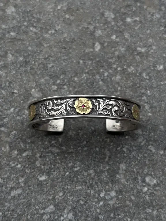 客定新品9宫格
材质：925银+18k金
设计：三花（三种形态全开、半开、花蕊） +鱼子纹唐草满刻+18k守护鹰。背部满背鹰编号025
尝试了用925银直接锻打镯体本身
翻边是一体锻打而成，非焊接
P