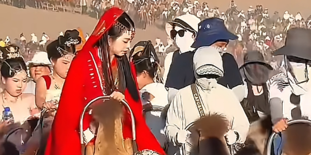 五一期间，敦煌鸣沙山被游客填满，骆驼三班倒“强制下班”