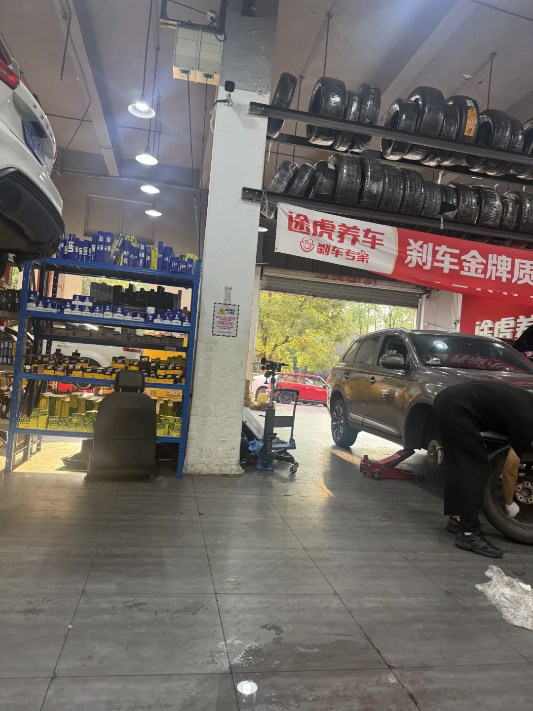 途虎养车工场店内景，配件货架与施工工位