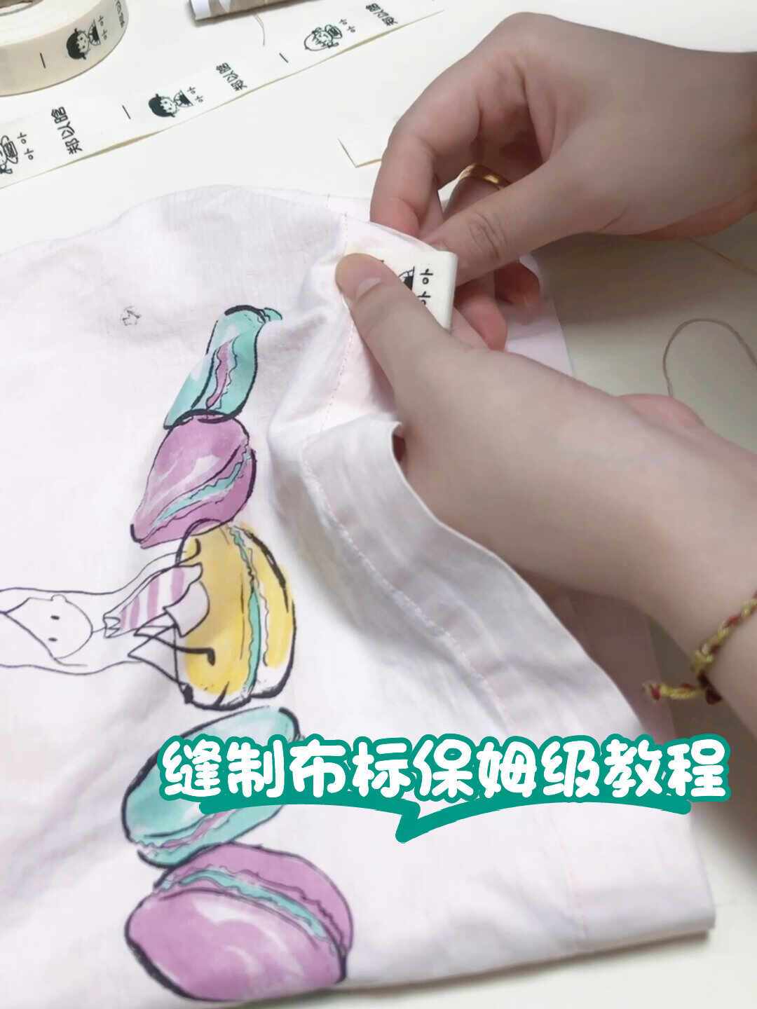 手工把布标缝到孩子衣物上