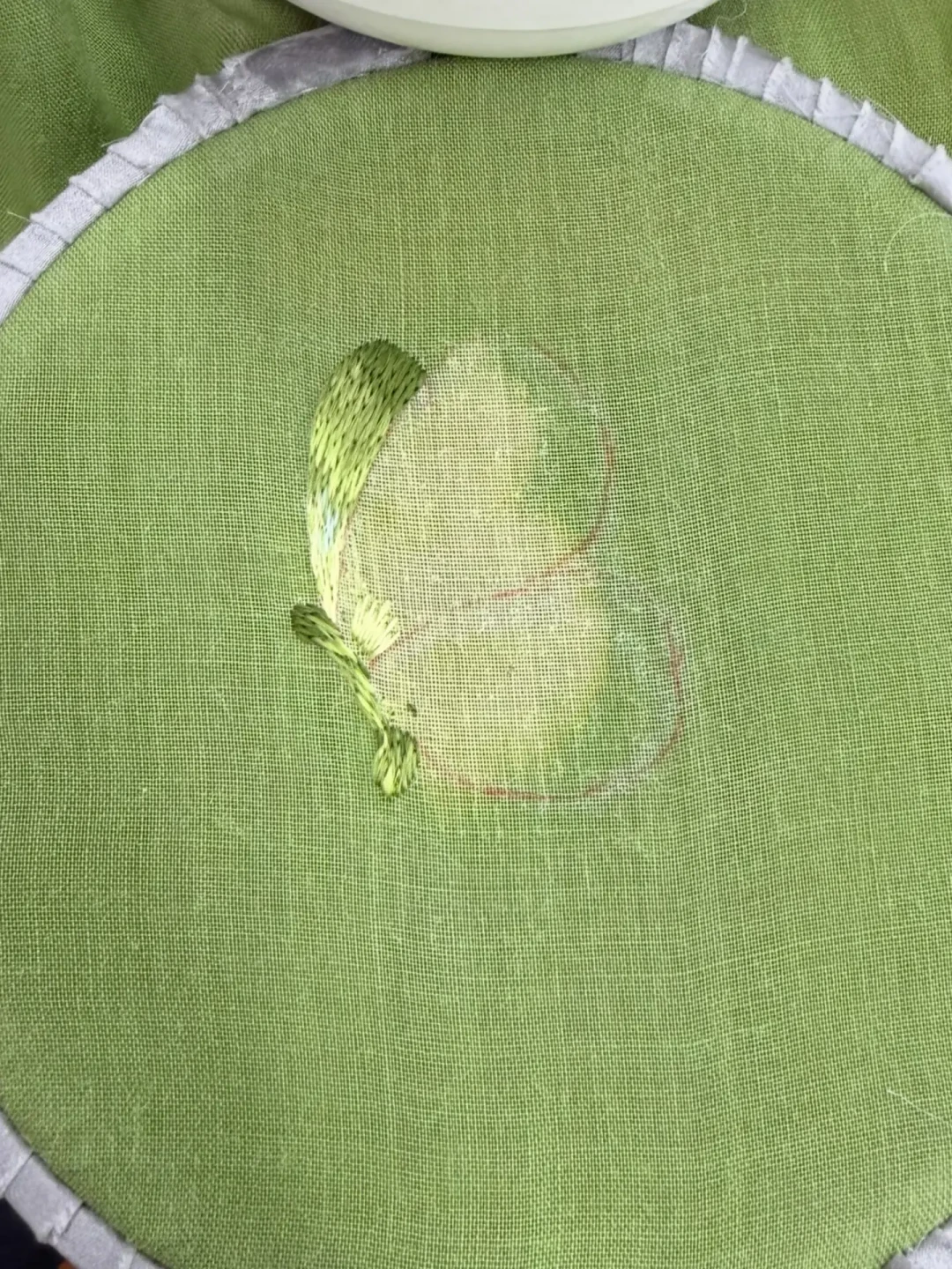 绣绷上架着底衬、刚绣出一翅的蝴蝶