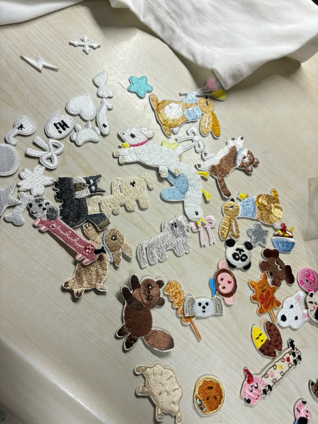 桌上摊开的一堆免绣直接熨的刺绣贴片