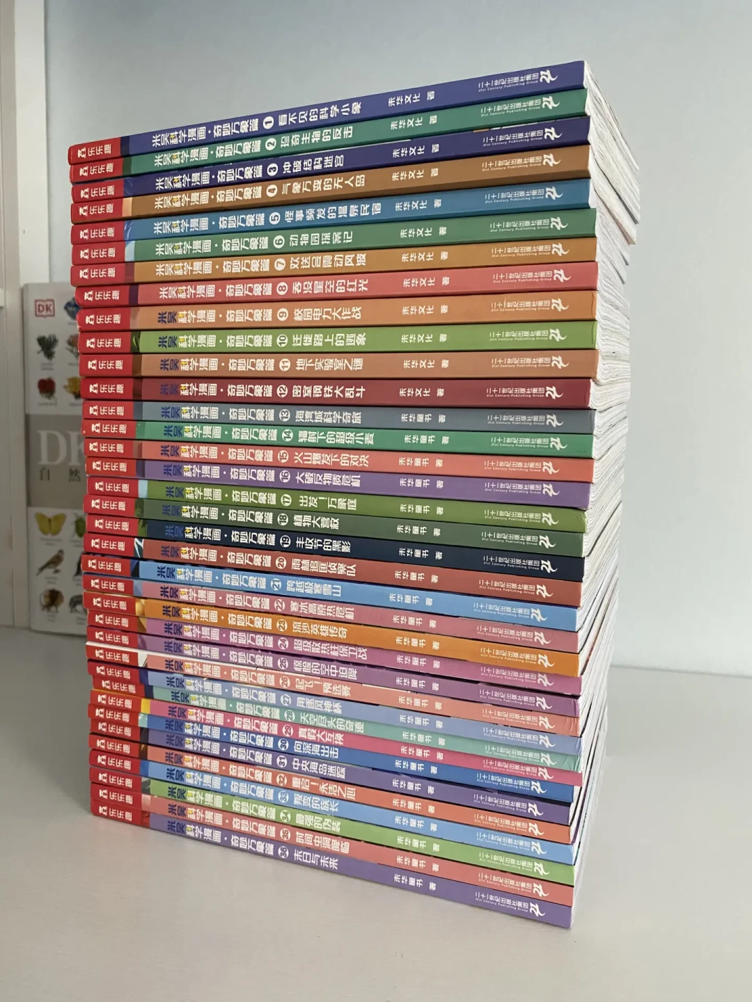 桌面上一大摞米吴科学漫画书脊堆叠的实拍图