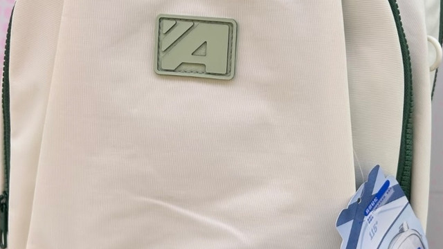 奶油绿边双肩包的设计特点