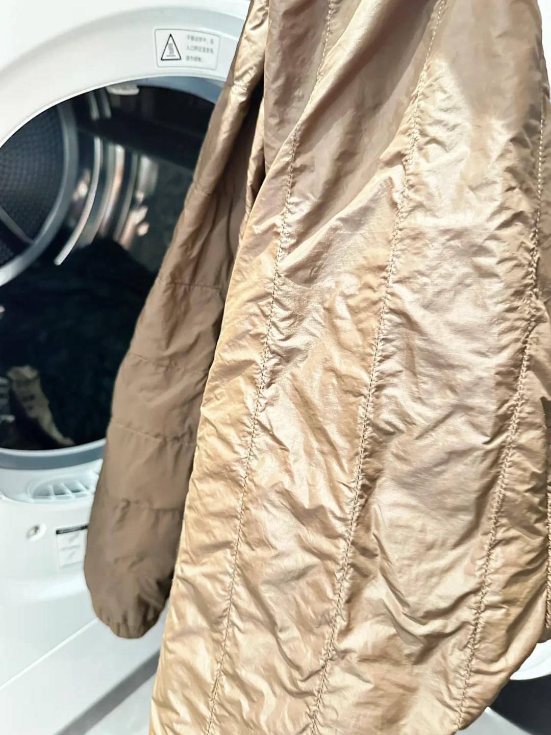 羽绒服换季拿出来又扁又皱?别急着拍、更别急着重洗:先分清「瘪了气」还是「绒成坨」,再决定挂、烘还是放弃抢救