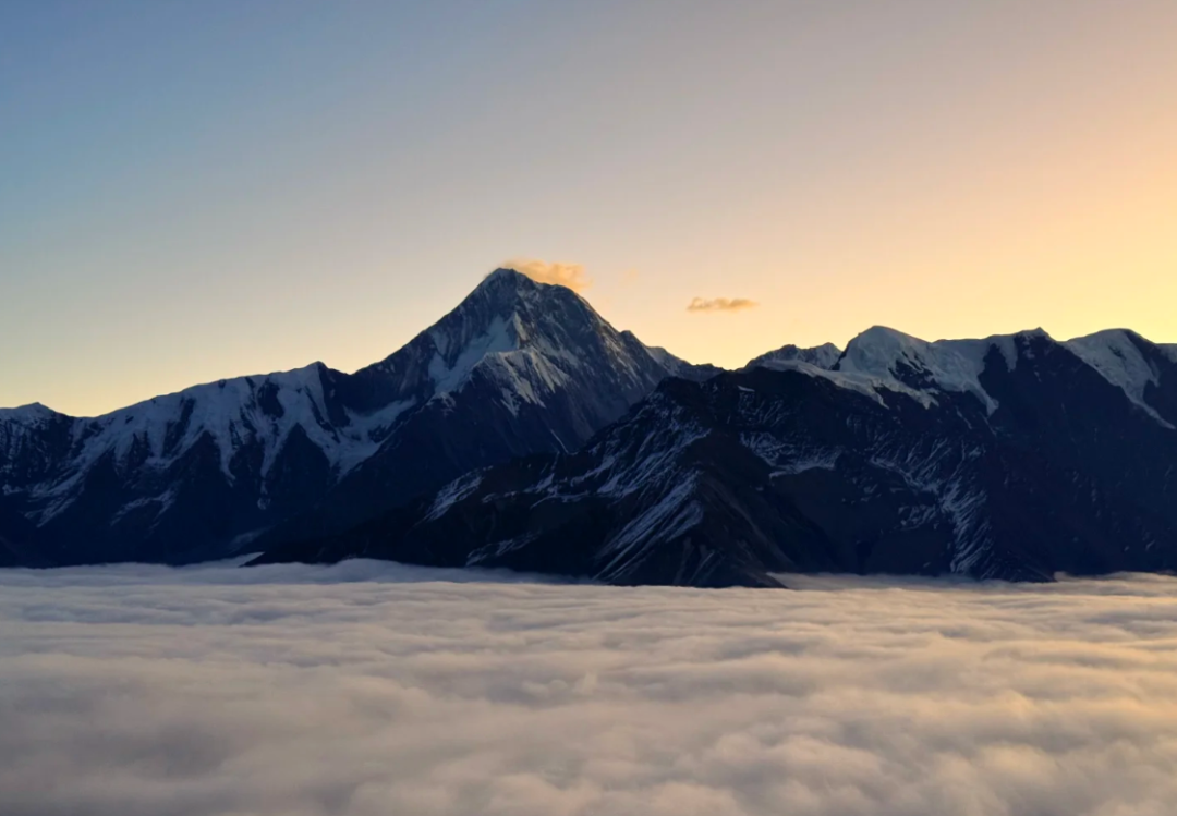 日落暖光下的雪山与云海
