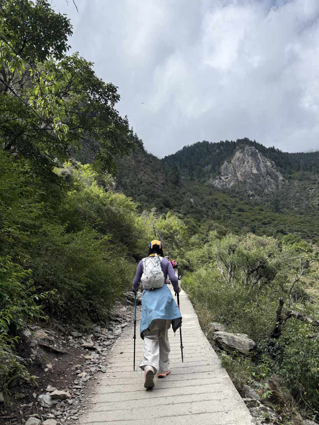 背包持杖走在山间石板栈道（雨崩5天4夜清单帖实拍）