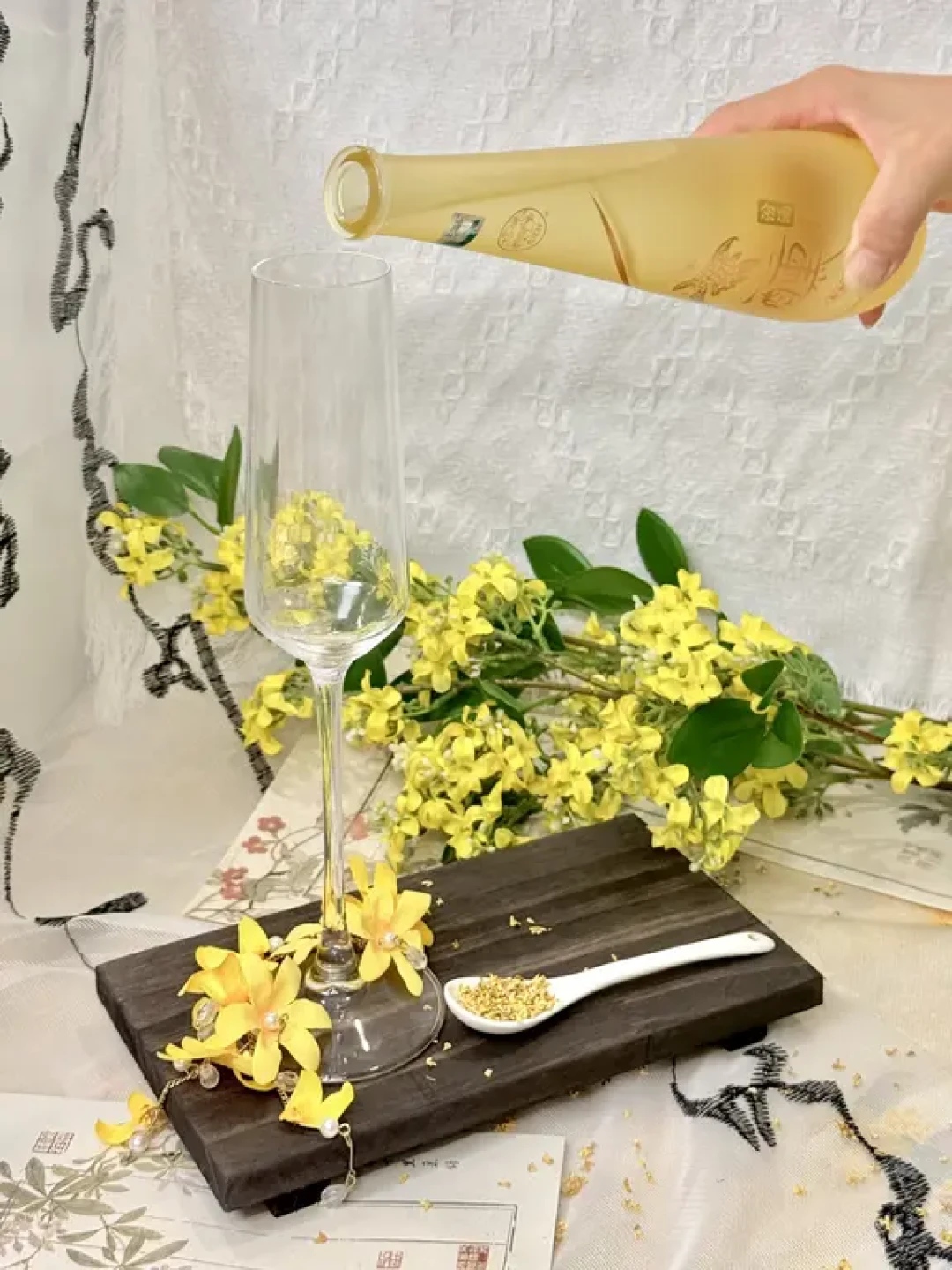 手持酒瓶向杯中斟桂花酒