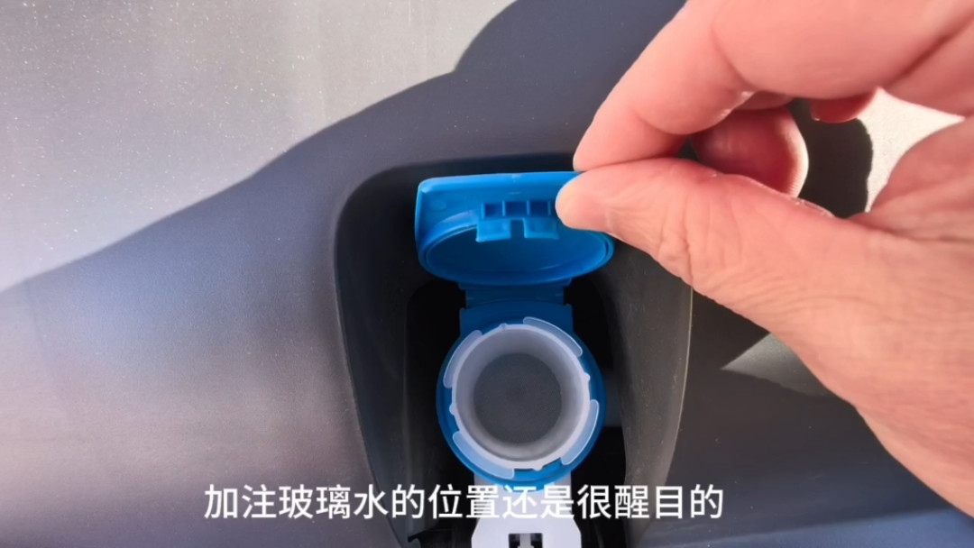 手指掀开蓝色玻璃水加注口盖